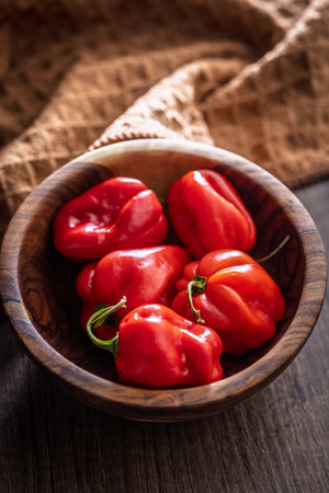 Red chili pepper habanero in bowl on a wooden table.の写真素材