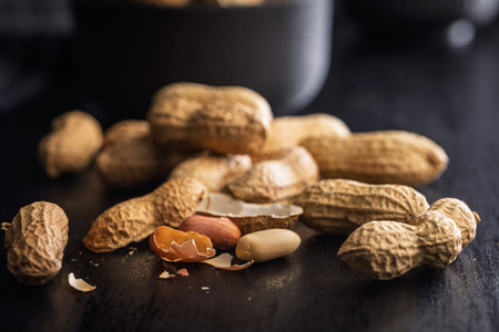Peanuts in shell. Groundnuts on a black table.