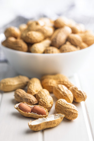 Peanuts in shell. Groundnuts on a white table.