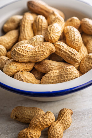 Peanuts in shell. Groundnuts in a bowl on a kitchen table.