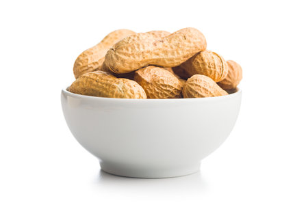Peanuts in shell. Groundnuts in bowl isolated on a white background.の写真素材