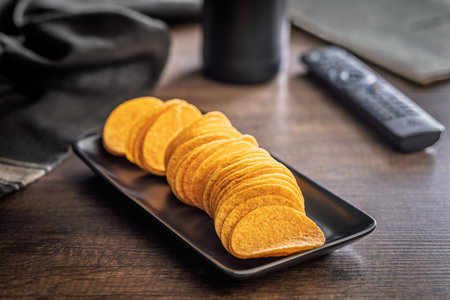 Crispy potato chips on a plate on a wooden table.の写真素材