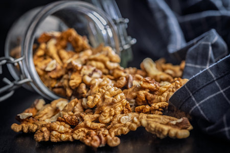 Peeled walnut kernels in a jar on a black table.の写真素材
