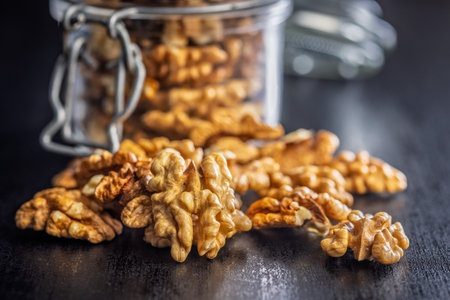 Peeled walnut kernels on a black table.の写真素材