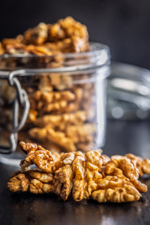 Peeled walnut kernels on a black table.の写真素材
