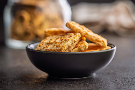 Crunchy salted crackers in a bowl on a black table.の写真素材