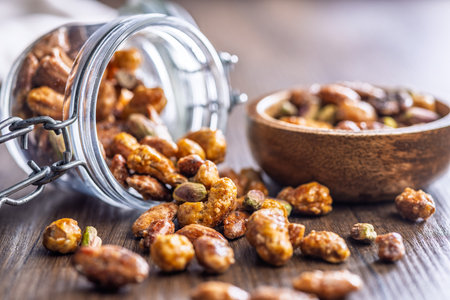 Nuts coated in sugar glaze on a wooden table.の写真素材
