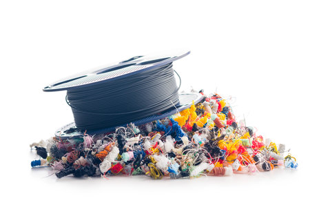 3D printer waste and filament spool. Plastic filament isolated on a white background.