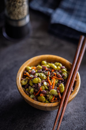 Fresh salad with edamame beans in a bowl on a black table.の写真素材