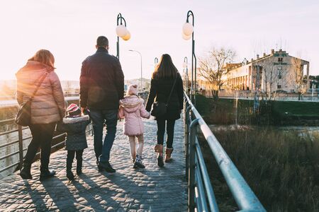 Father walking down the street with his two families on a sunny winter's afternoon. Atypical family conceptの写真素材