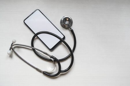 Mockup of the phone with the stethoscope checks the health. Online medical clinic communication with the patient. Online doctor conceptの写真素材