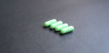 Close-up view of green pills on a black background. Concept of medicineの写真素材