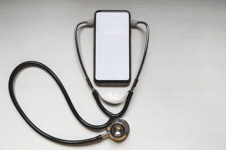 Mockup of the phone with the stethoscope checks the health. Online medical clinic communication with the patient. Online doctor conceptの写真素材