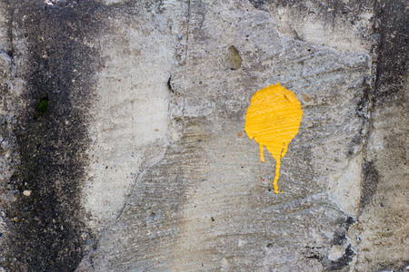 Yellow paint stain (one) on old and dirty wall. The surface of the concrete (stone) is not smooth.の写真素材
