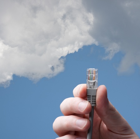 Cloud computing concept. Hand with cable connecting into cloud.の写真素材