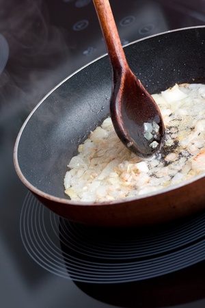 Fried onion in frying-pan and spoonの写真素材