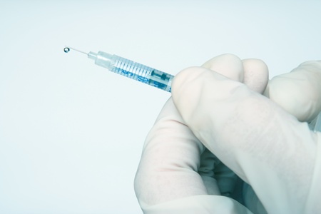 Closeup hands with injection - blue tint medical conceptの写真素材