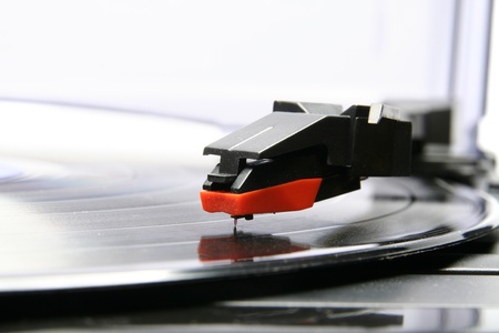 Gramophone with vinyl disc against white background