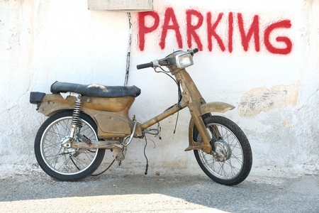 Retro motorcycle leaned on wall with sign Parkingの写真素材