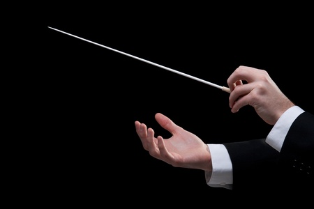 Male orchestra conductor hands, one with baton. Black background.の写真素材