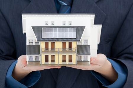 Real estate agent offer house with solar panels represented by model の写真素材