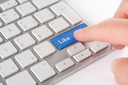 Like button on computer keyboard pressed by user - social network concept  の写真素材