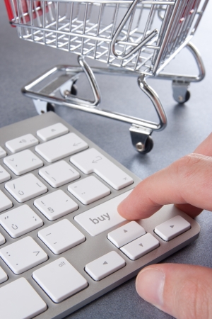 E-shop (e-commerce) concept - keyboard with buy text and shopping cart (shopping trolley) in background.
の写真素材