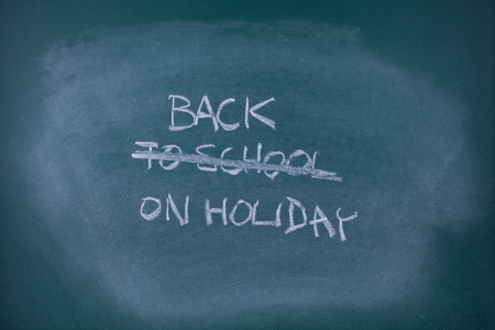 Back on holiday concept  Writing back to school scored out and replaced with text back on holiday, school chalkboard  blackboard  の写真素材