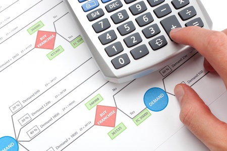 Making business decision about franchise  franchising   Printed decision tree and man calculating on calculator の写真素材
