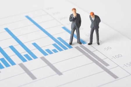 Business report, graph and business figurines illustrating profit decrease analyze  の写真素材