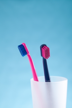 Two toothbrushes - dental hygiene  Selective focused on front toothbrush, blue background の写真素材