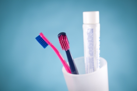 Two toothbrushes and toothpaste - dental hygiene  Selective focused on front toothbrush, blue background  の写真素材