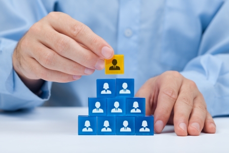 Human resources and corporate hierarchy concept - recruiter complete team by one leader person  CEO  represented by gold cube and icon  の写真素材