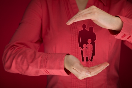 Family life insurance, family services, protecting family, family policy and supporting families concepts. Woman with protective gesture and silhouette representing young family.
の写真素材