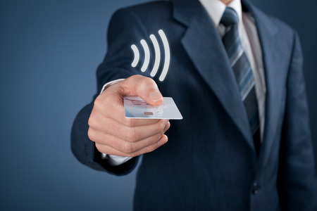 Contactless payment concept. Man pay with contactless credit card, virtual contactless symbol above card.の写真素材