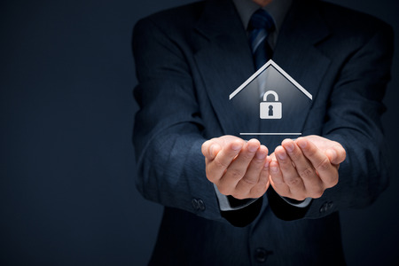 Property security concept. Offering gesture of man and symbol of house with padlock.の写真素材