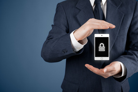 Mobile device (mobile phone, cellphone, tablet) security concept. Protecting gesture of man and symbol of mobile device with padlock.の写真素材