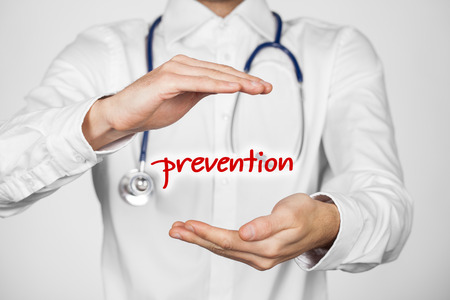 Healthcare prevention doctor (general practitioner) concept. Doctor with protective gesture and text prevention.の写真素材
