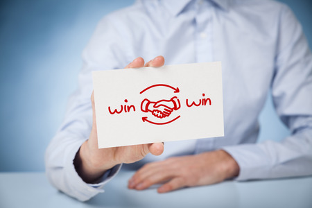 Win-win partnership strategy concept. Businessman with drawn win-win scheme on card and handshake partnership agreement.の写真素材