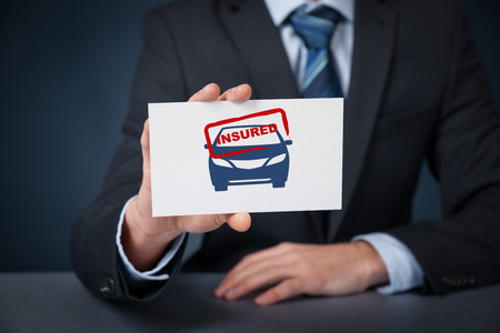 Insured car concept. Insurance agent with car silhouette on card and printed stamp insured.の写真素材