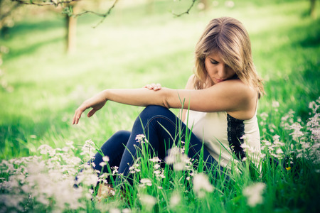 Woman relax in grass in springtime. Blurred background with bokeh.の写真素材