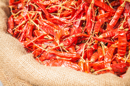 Red dried chilli peppers in sack, detail.の写真素材