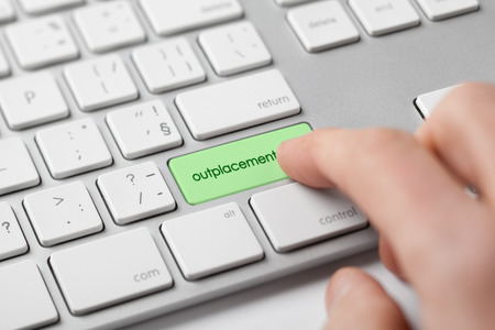 Outplacement concept. Man push keypad outplacement on keyboard.の写真素材
