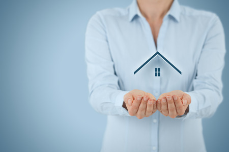 Property insurance and security concept. Protecting gesture of man and symbol of house.の写真素材