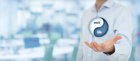 Work life (work-life) balance concept. Life coach (career manager) give advice about work-life balance, wide composition with office in background.の写真素材