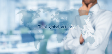 Think global, act local. Globalization business rule. Businessman think about this rule. Wide banner composition, office in background. Think global, act local. Globalization business rule. Businessman think about this rule. Wide banner composition, office in background.