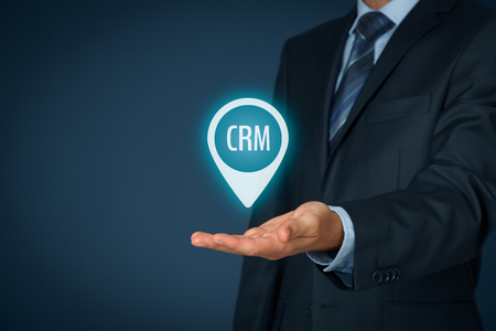 Customer relationship management (CRM) concept. Businessman hold virtual label with text CRM.の写真素材