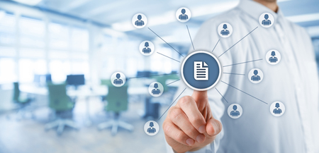 Corporate data management system (DMS) and document management system concept. Businessman click (or publish) on document connected with corporate users working on notebooks with access rights. Wide banner composition with office in background.の写真素材