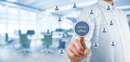 Home office (home-office) concept. Businessman click on home office button linked with employees working on notebooks. Wide banner composition with void office in background.の写真素材