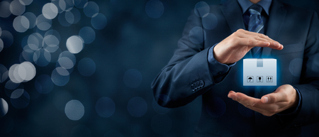 Cargo (freight) insurance concept. Businessman with protective gesture and insured package. Wide banner composition with bokeh in background.の写真素材